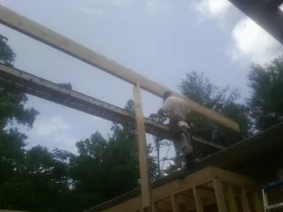 Carpenter setting a ridge beam over a new addition frame — Ice Dam Removal by Roofing Brothers in Immaculata