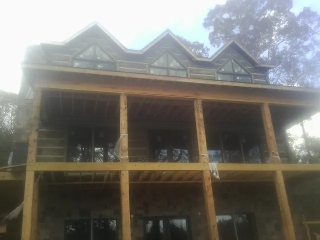 Dormers and porch framing on a large log home under construction — Roof Coating work by our crew in Immaculata