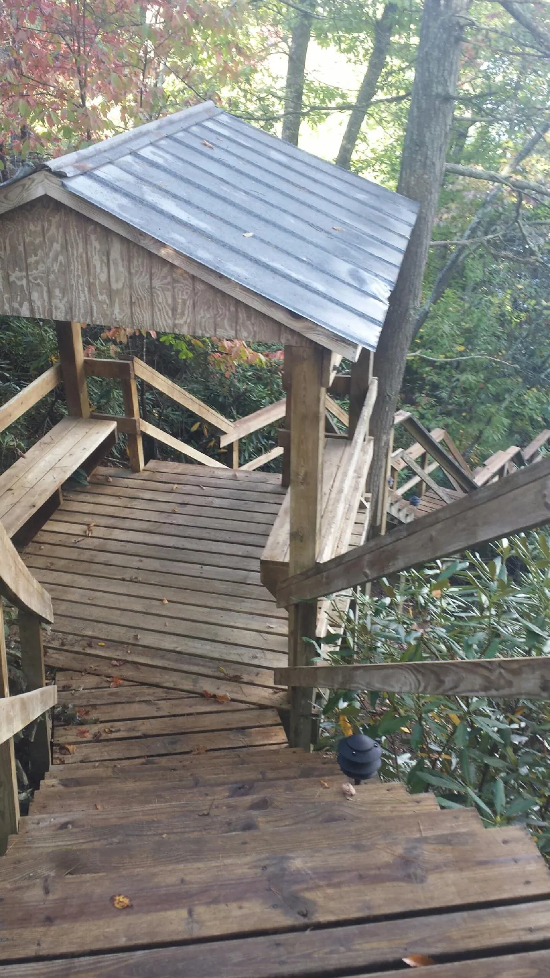 Metal roofed shelter over wooden steps on a wooded walkway — Skylight Repair & Installation work by our crew in Immaculata