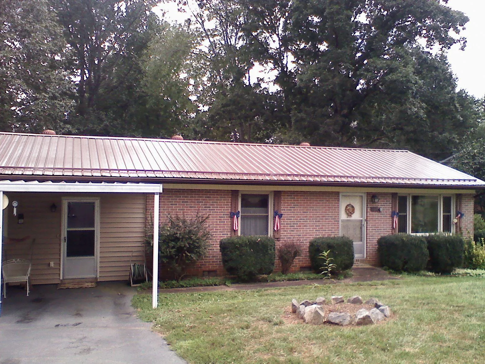Bronze metal roof and carport on a brick ranch home — Roof Repair work by our crew in Immaculata